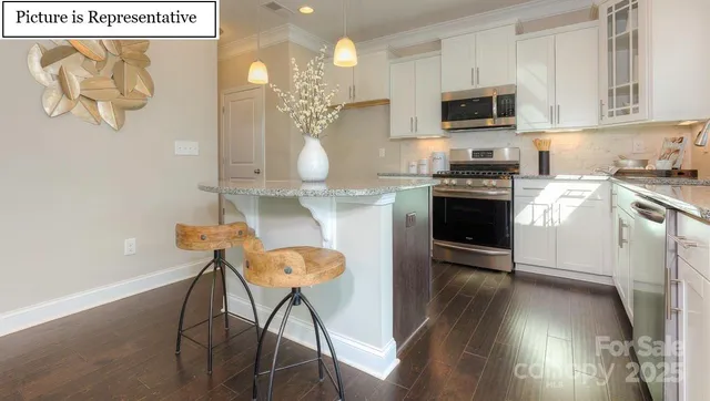 a kitchen with granite countertop a stove top oven a sink a dining table and chairs