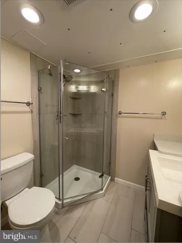 a bathroom with a shower a toilet and a sink