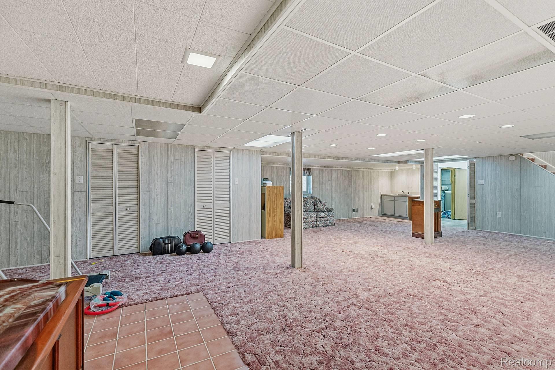 70919 Coon Creek Road Armada, MI 48005 - Photo 34 of 50 Finished below grade area with a drop ceiling, wood walls, and light carpet