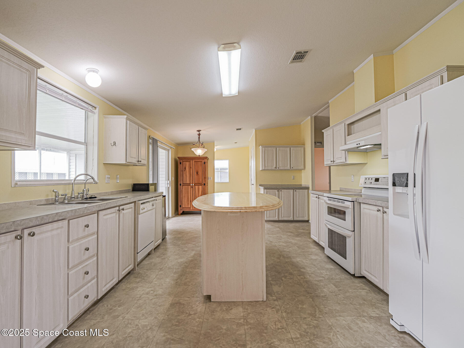 7620 Boxelder Road Micco, FL 32976 - Photo 13 of 47 a large kitchen with a large counter top appliances and cabinets