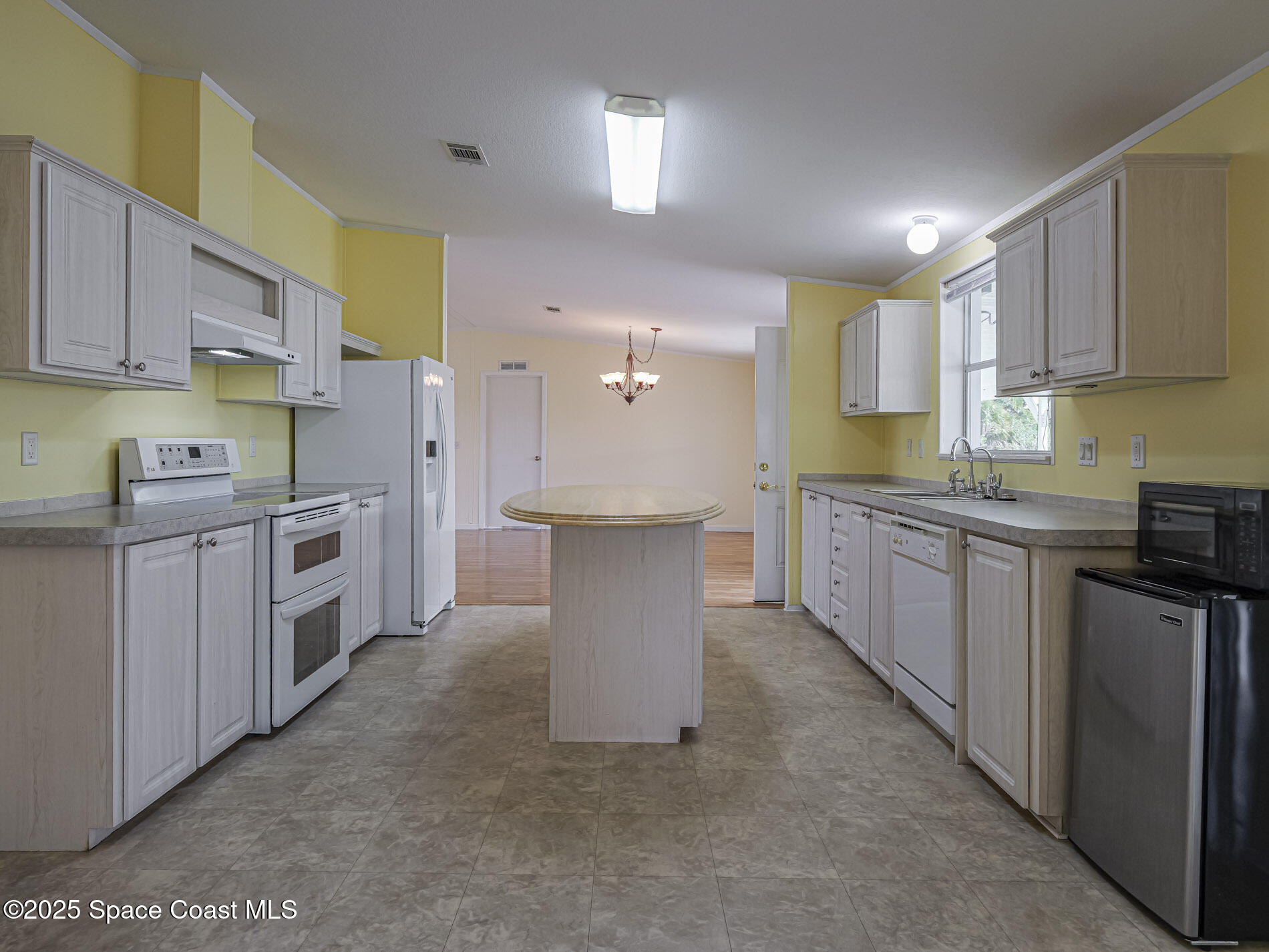 7620 Boxelder Road Micco, FL 32976 - Photo 15 of 47 a kitchen with a white cabinets stove sink and dishwasher with wooden floor