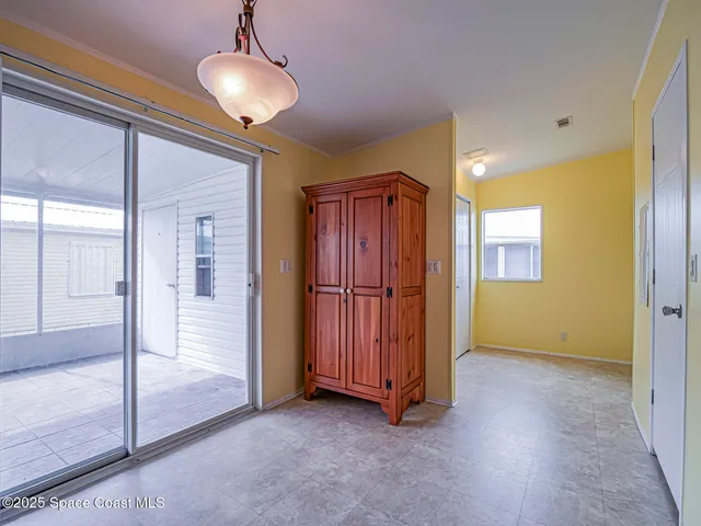 a view of a livingroom with wooden floor and a bathroom