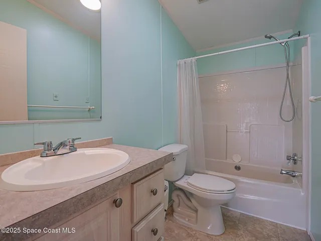 a view of a room with wooden floor and a ceiling fan