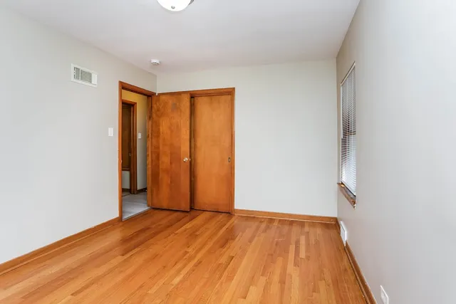 an empty room with wooden floor and closet