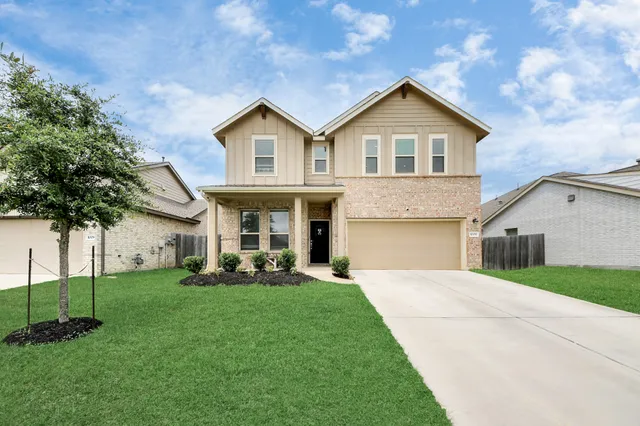 a front view of a house with a yard and trees