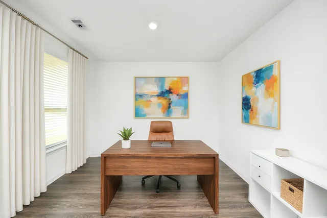a view of a workspace with furniture and wooden floor