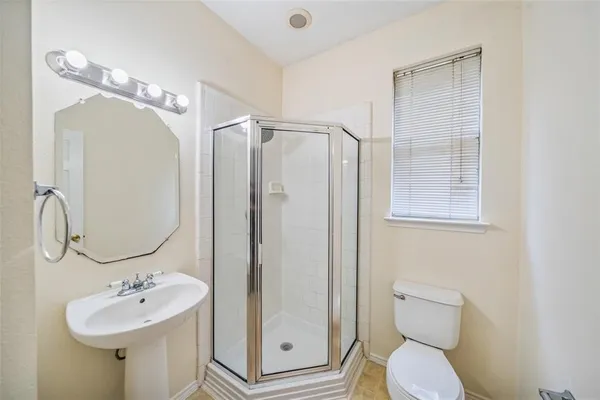 a bathroom with a toilet sink shower and mirror