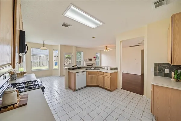 a large kitchen with a stove a sink dishwasher and a refrigerator