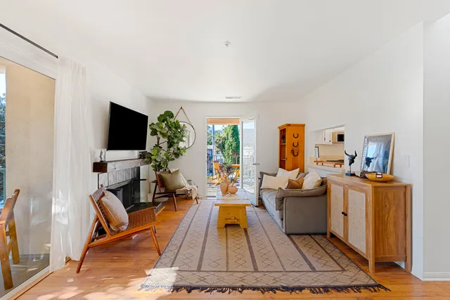 a living room with furniture a flat screen tv and a rug