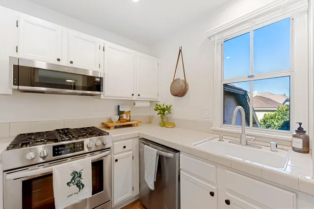 a kitchen with granite countertop a sink stainless steel appliances and cabinets