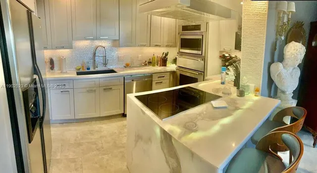 a kitchen with stainless steel appliances granite countertop a sink a stove and a refrigerator