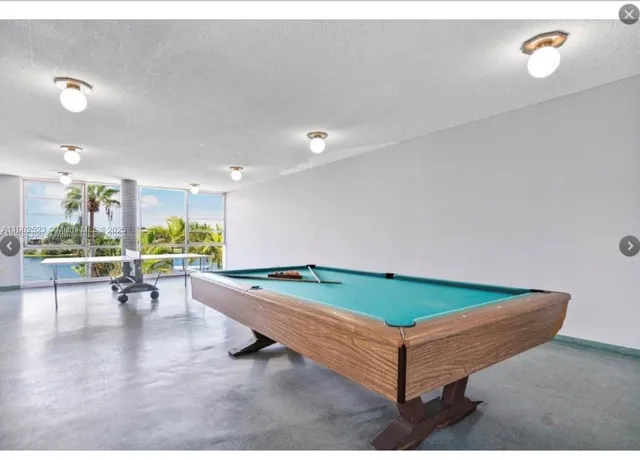 a room with pool tables and windows