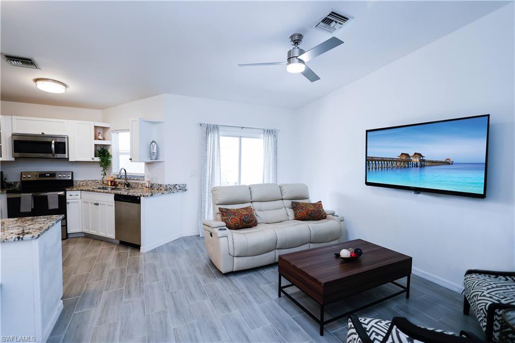 650 103rd Avenue North Naples, FL 34108 - Photo 3 of 13 a living room with furniture and kitchen view