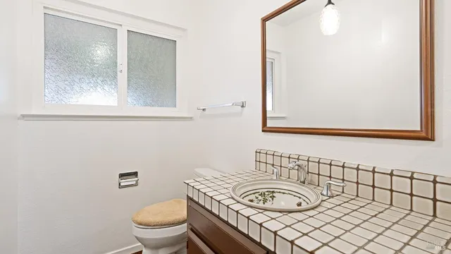 a bathroom with a toilet a sink and mirror