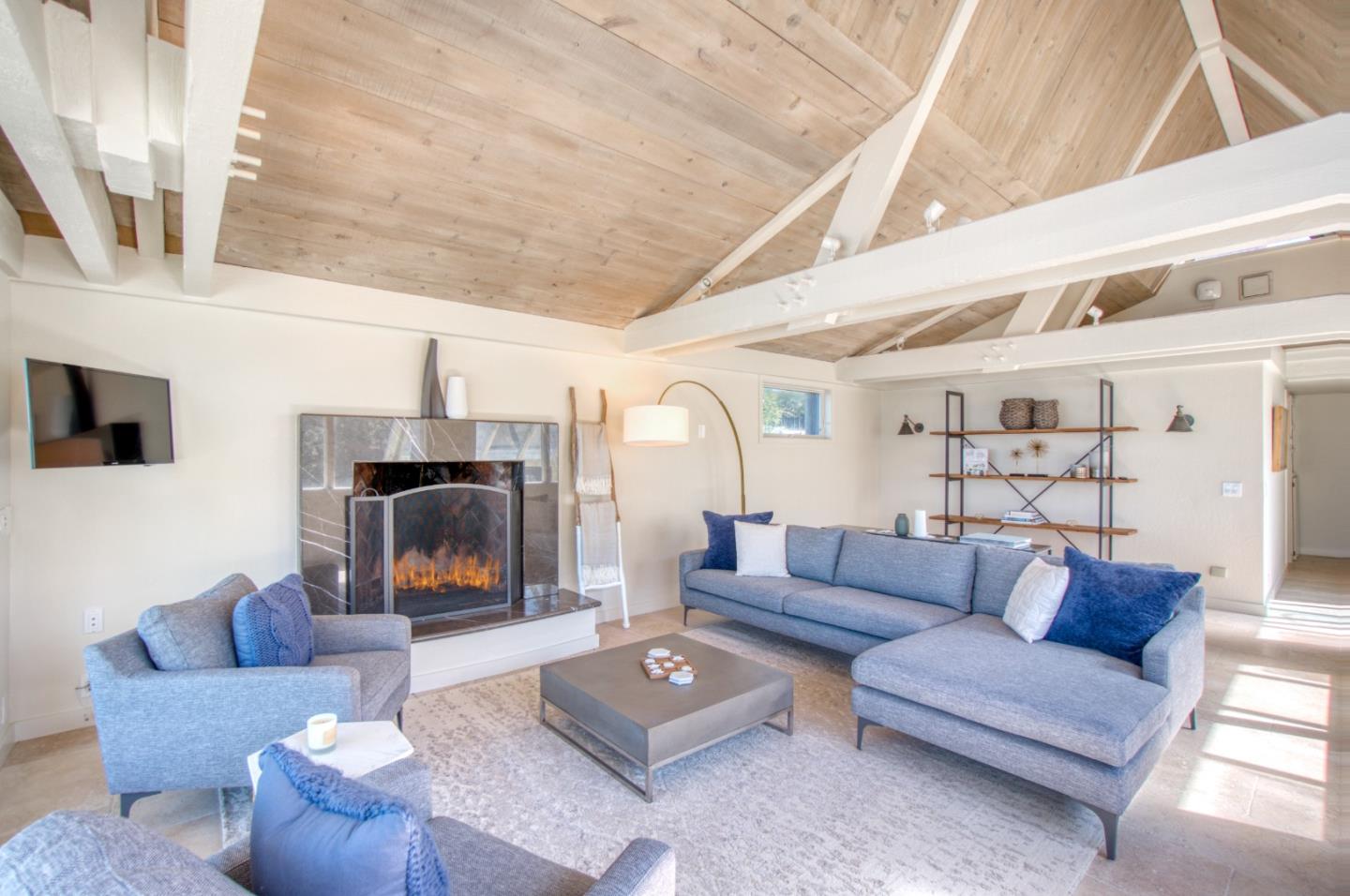 191 Reef Point Road Moss Beach, CA 94038 - Photo 12 of 41 a living room with furniture a fireplace and a flat screen tv