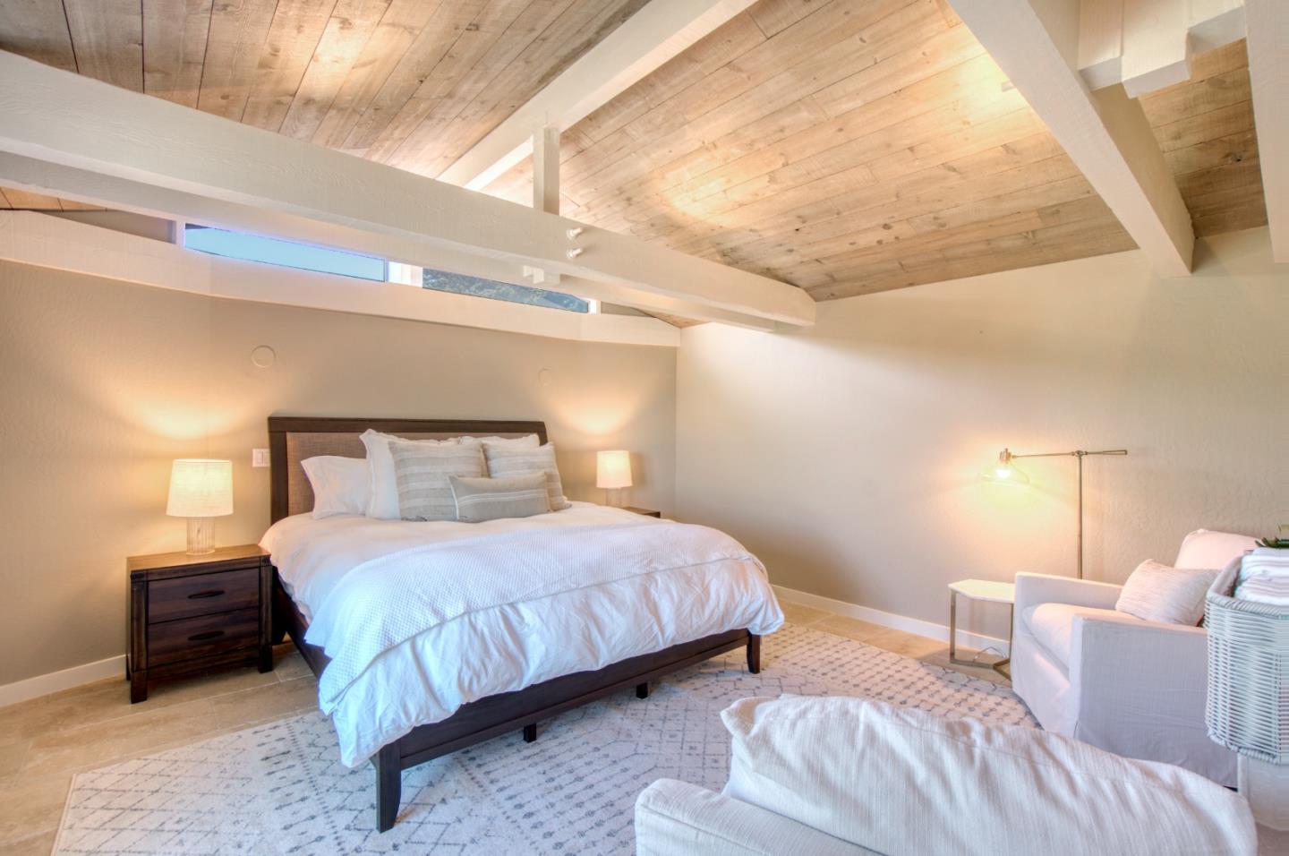 191 Reef Point Road Moss Beach, CA 94038 - Photo 14 of 41 a bedroom with a bed a lamp and a window