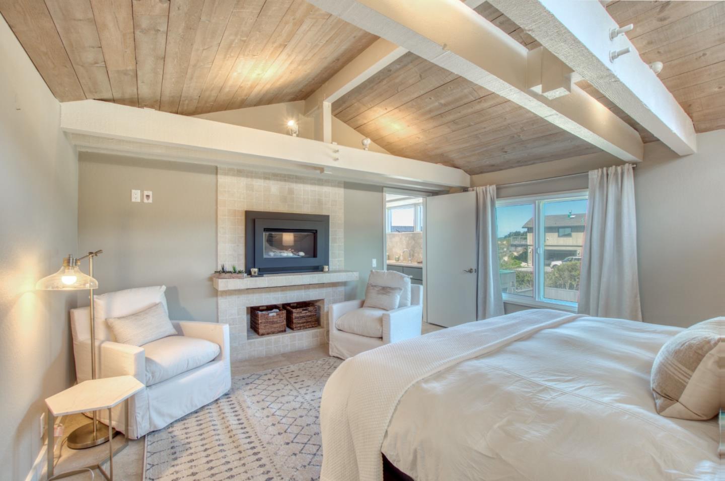 191 Reef Point Road Moss Beach, CA 94038 - Photo 15 of 41 a spacious bedroom with a bed and a couch