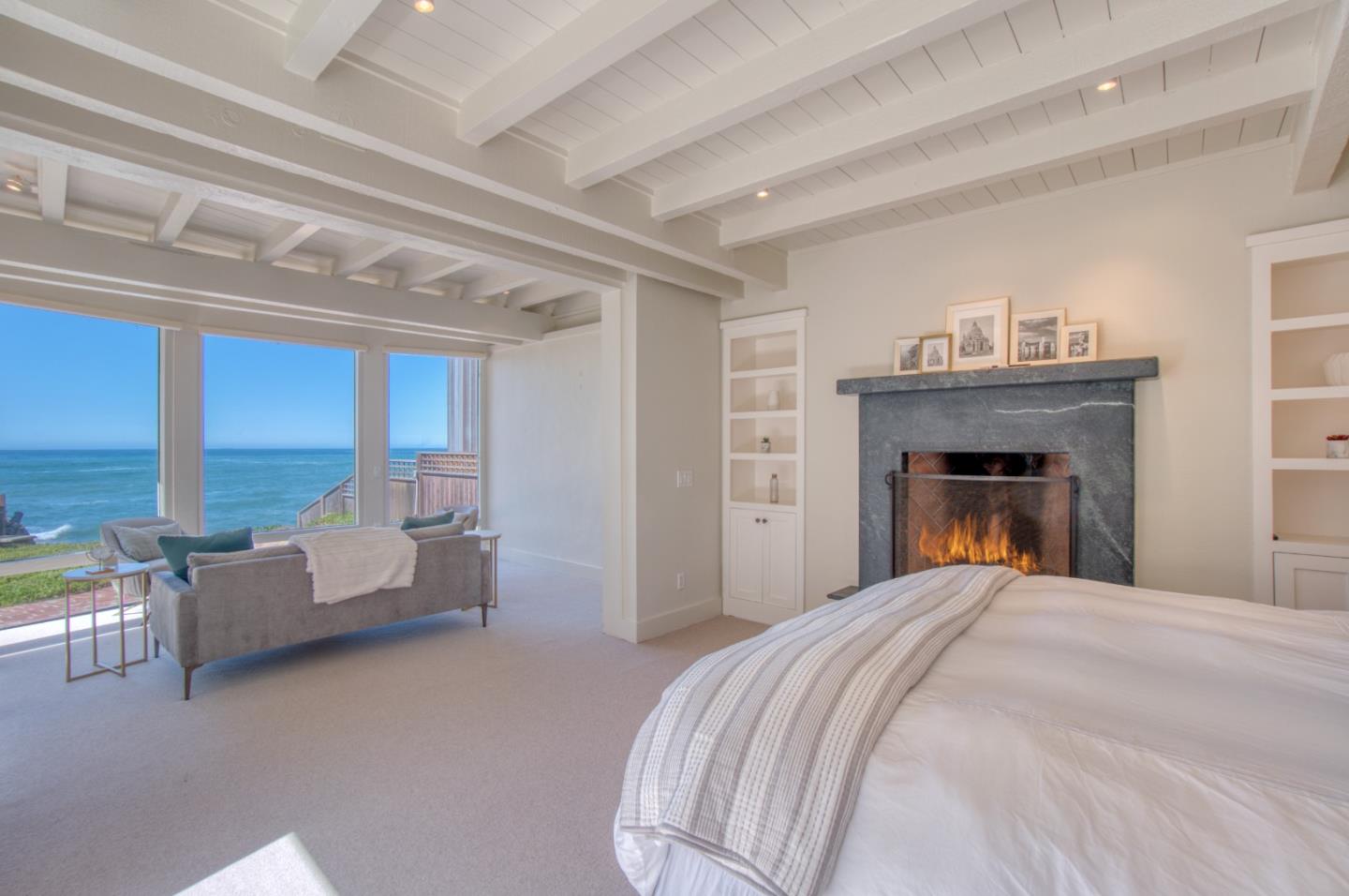 191 Reef Point Road Moss Beach, CA 94038 - Photo 25 of 41 a bedroom with a bed and a fireplace