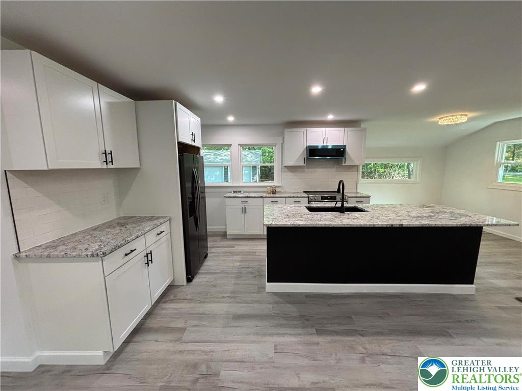 250 Bird Lane Kunkletown, PA 18058 - Photo 11 of 40 a kitchen with granite countertop white cabinets and black stainless steel appliances