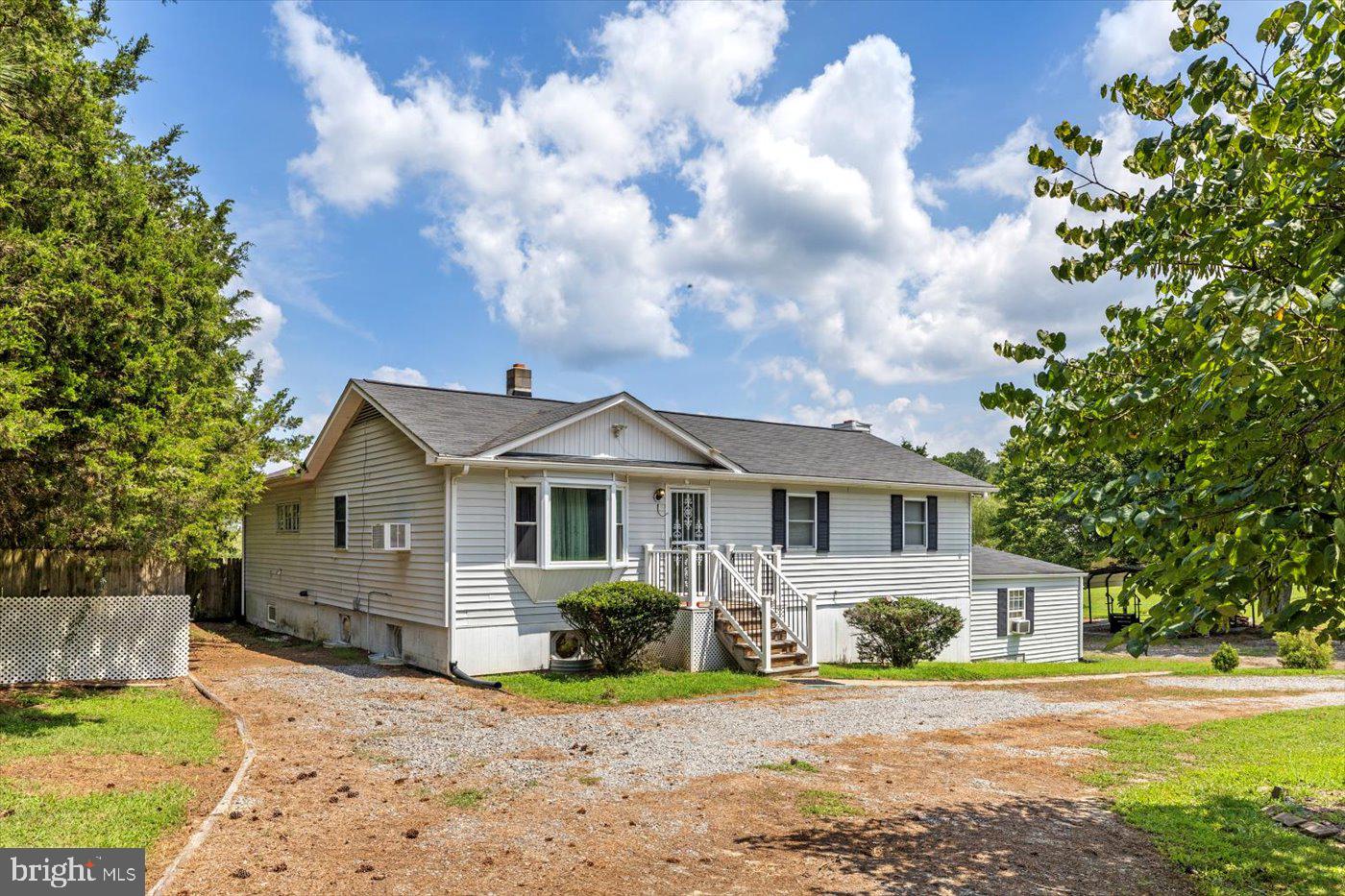 Exterior photo with wrap around gravel driveway