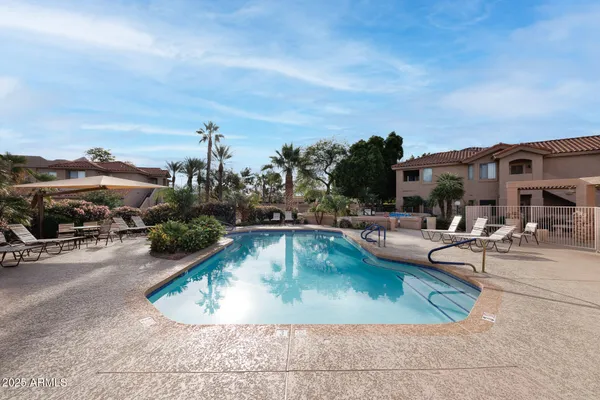 a view of a swimming pool with outdoor seating and plants