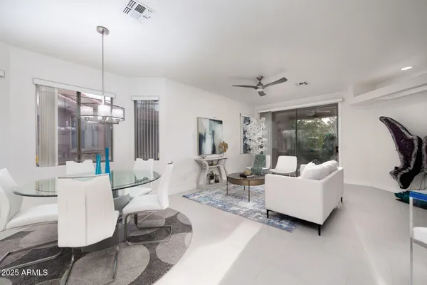 a living room with furniture a ceiling fan and a window