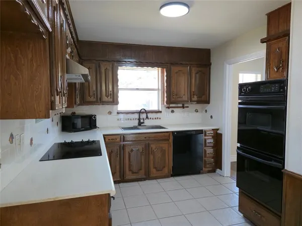 a kitchen with a sink a stove and cabinets