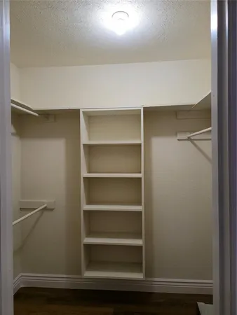 a view of walk in closet with empty racks