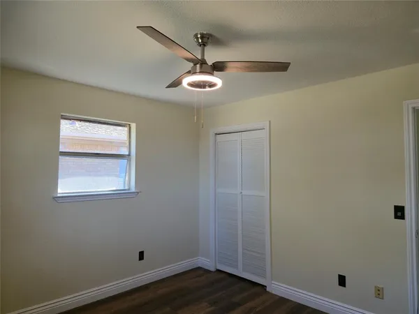 a view of room with hardwood floor and ceiling fan
