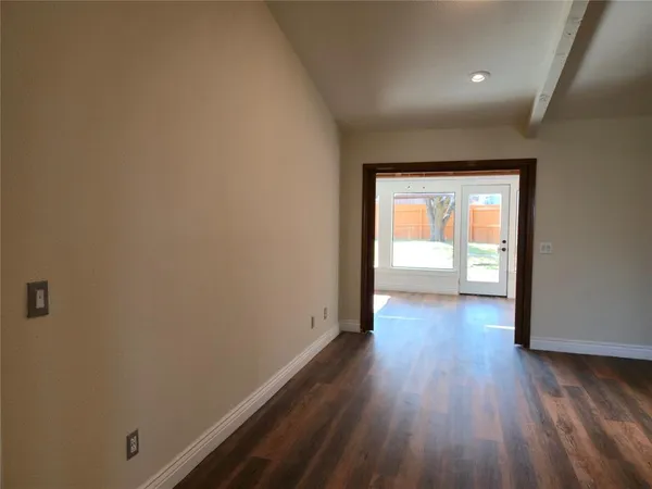 a view of a room with wooden floor and a window