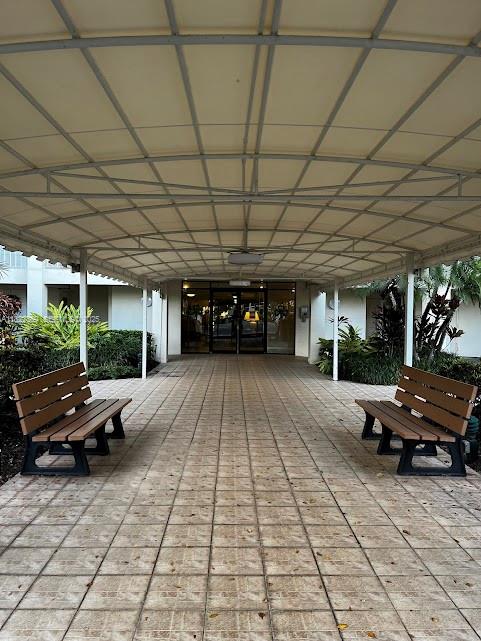 3090 North Course Drive, Unit 807 Pompano Beach, FL 33069 - Photo 5 of 10 a view of a patio with table and chairs with wooden floor and fence