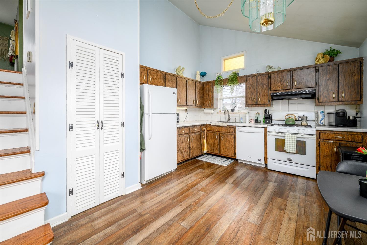 109 Hickory Road Colonia, NJ 07067 - Photo 7 of 34 a kitchen with a white cabinets a sink dishwasher and a stove with wooden floor