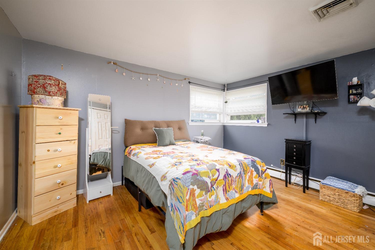 109 Hickory Road Colonia, NJ 07067 - Photo 8 of 34 a bedroom with a bed and a flat tv screen on dresser