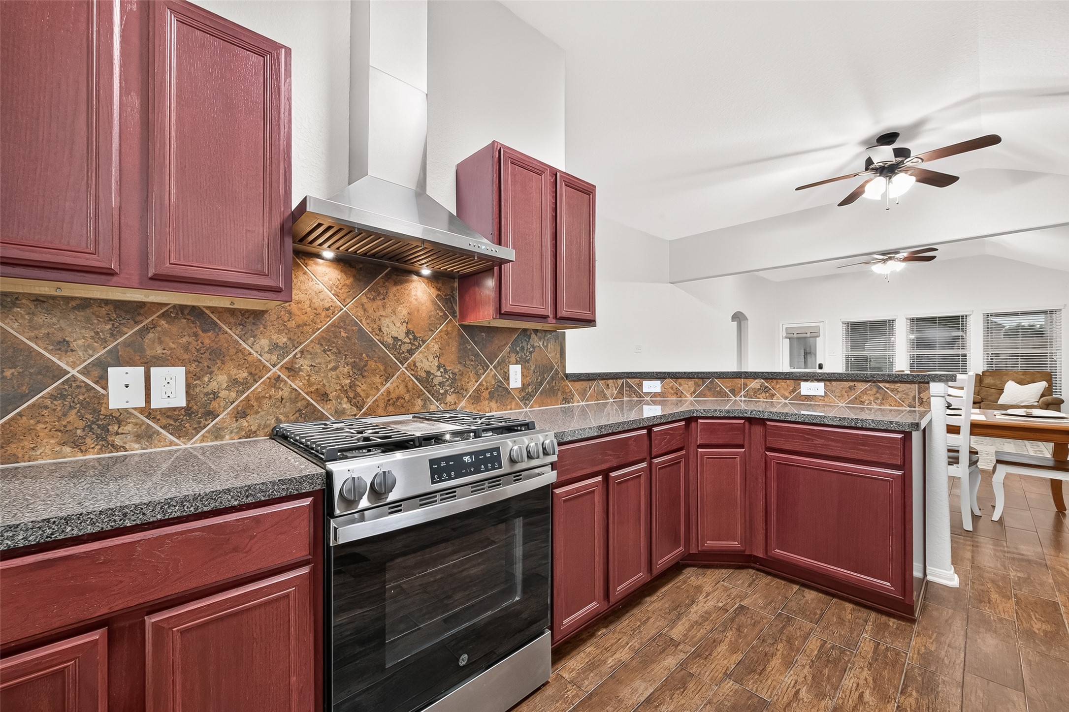 3155 View Valley Trail Katy, TX 77493 - Photo 21 of 50 Stunning kitchen view featuring a contemporary vent hood, tile backsplash, and seamless open flow