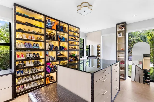 a view of walk in closet with clothes and shoes