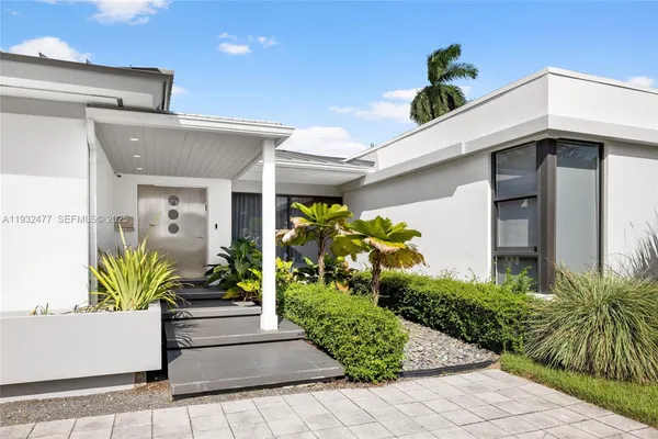 a front view of a house with potted plants
