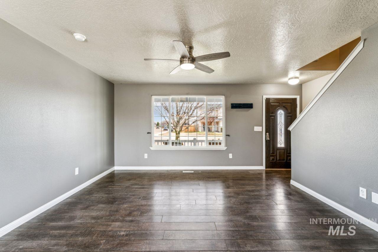 5410 Barkley Way Caldwell, ID 83607 - Photo 12 of 50 Foyer with a ceiling fan, a textured ceiling, dark wood-style floors, and a textured wall