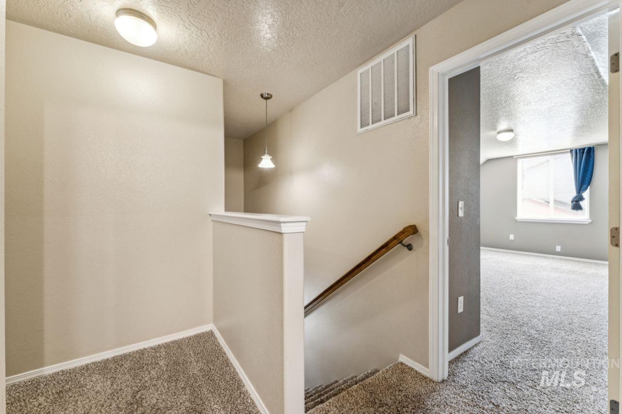 5410 Barkley Way Caldwell, ID 83607 - Photo 23 of 50 Hall with carpet floors, an upstairs landing, and a textured ceiling