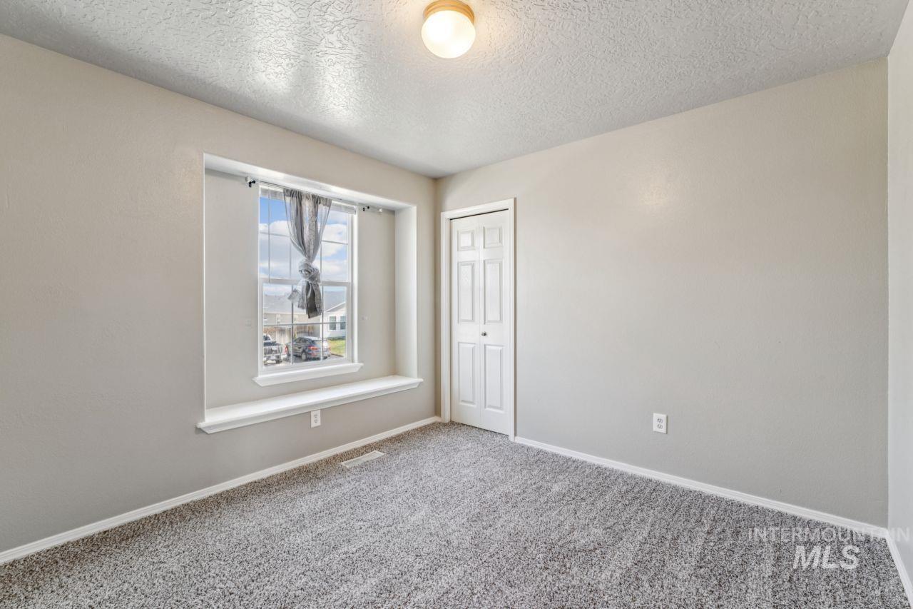 5410 Barkley Way Caldwell, ID 83607 - Photo 33 of 50 Carpeted spare room featuring a textured ceiling and baseboards