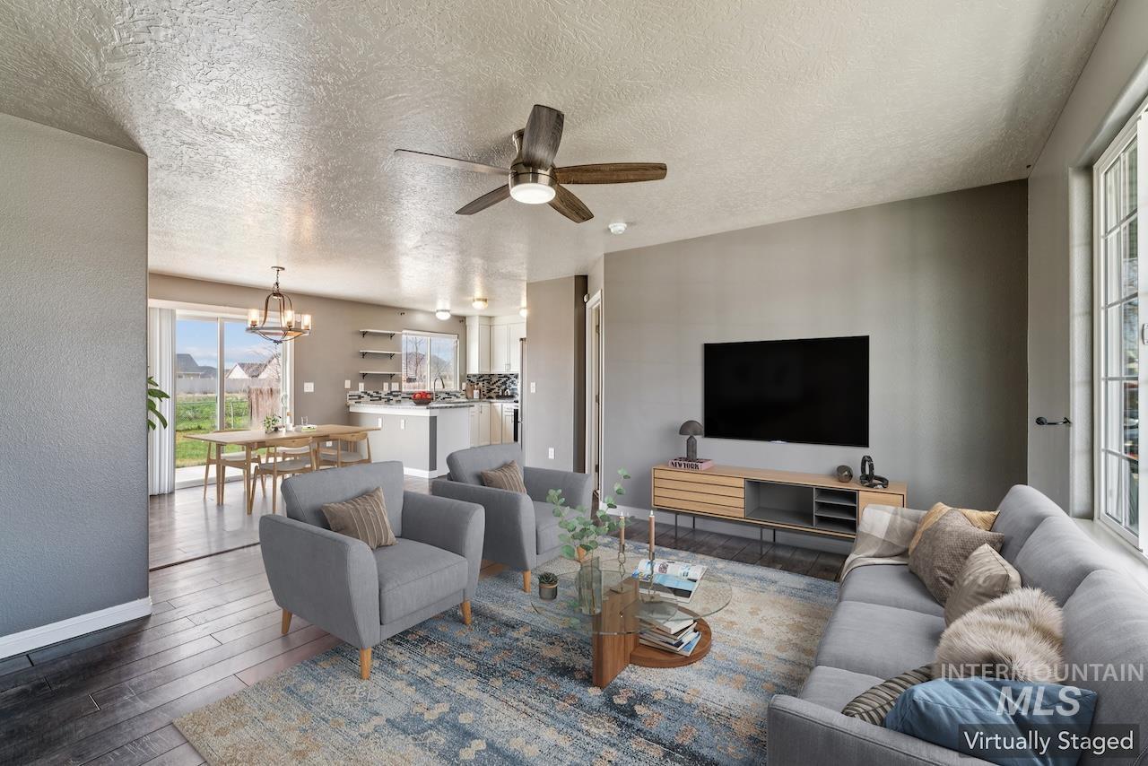 5410 Barkley Way Caldwell, ID 83607 - Photo 9 of 50 Living room featuring a ceiling fan, wood finished floors, a textured ceiling, suspended lighting, and a textured wall