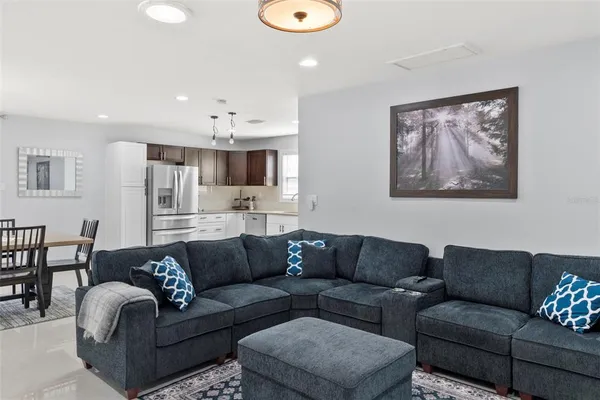a living room with furniture a couch and kitchen view