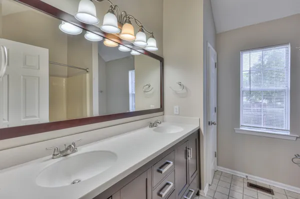 a bathroom with a sink a large mirror and a light fixture