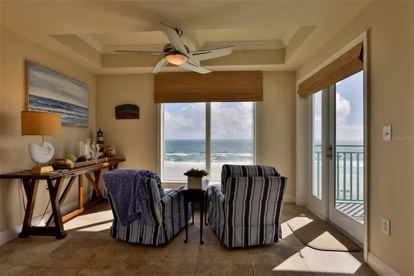 a living room with furniture kitchen view and a chandelier
