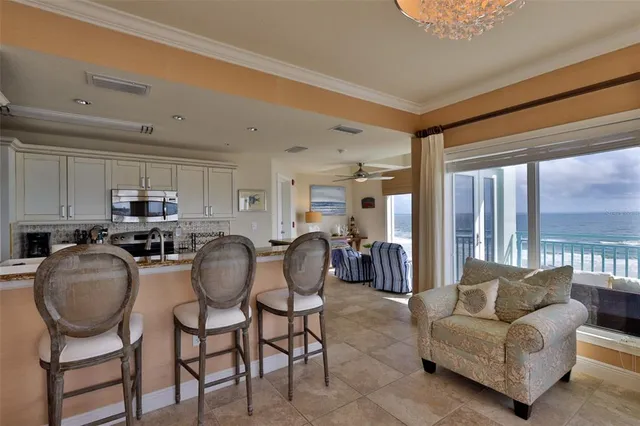 a living room with furniture kitchen view and a chandelier