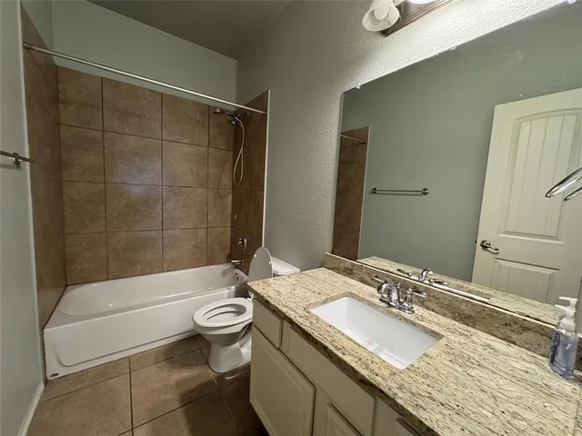 a bathroom with a granite countertop toilet sink and shower