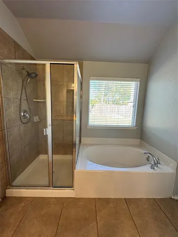 a bathroom with a bathtub and shower