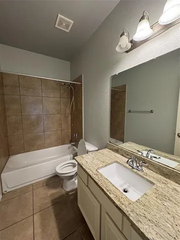 a bathroom with a granite countertop sink a toilet a mirror and shower