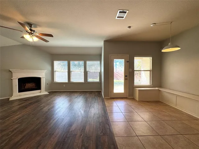 a view of an empty room with a fireplace and a window
