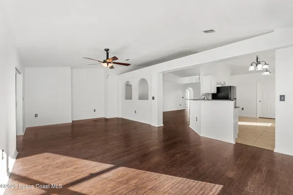 a view of a livingroom with wooden floor and a ceiling fan