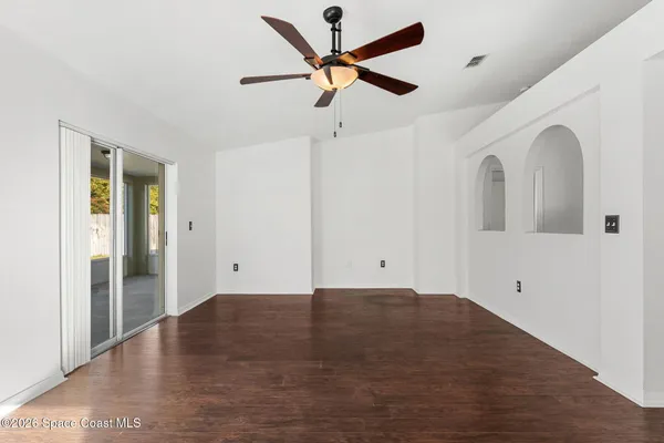 a view of empty room with wooden floor and window